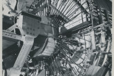 In this experiment, the magnetic trap was formed by currents flowing in two coaxial coplanar rings. 
Plasma was injected into the trap iron from a plasma gun and its stability was studied.
A technician adjusting a diagnostic probe.

(IAEA Archives/Credit: UKAEA, United Kingdom)