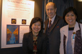 Agency employees from the medical service: Wai Yue Bernleitner, John Doherty, and Nida Tare in front of the Peace Prize Medal. (Photo credit: D. Calma/IAEA)